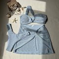 Women's light green one-shoulder swimsuit set with glossy top, high-waisted pants, and matching skirt.