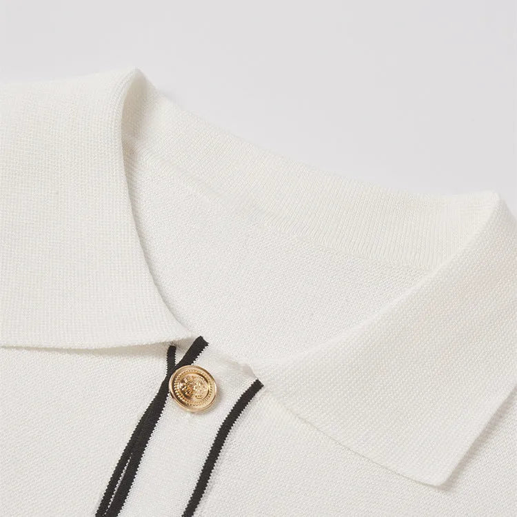 White short-sleeve cardigan with dark contrast colour lapels, buttoned front, on a hanger.