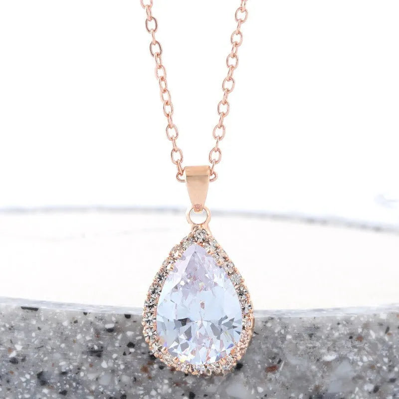 Rose gold water drop shaped necklace with geometric design and rhinestone accents in pink colour