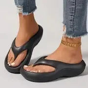 Women's black EVA flip flops with thick sole and non-slip tread on a plain background.