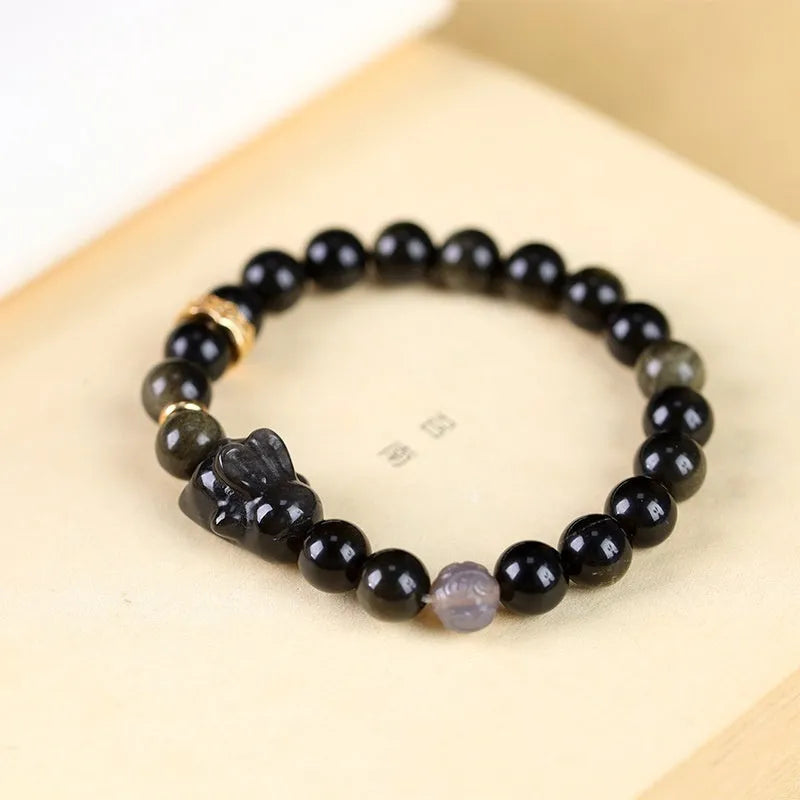 Handmade obsidian bracelet with lying rabbit charm, grey agate beads and brass metalwork in national style