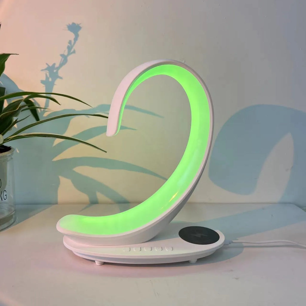White swan-shaped desktop wireless charger with integrated Bluetooth speaker and colourful LED atmosphere light.