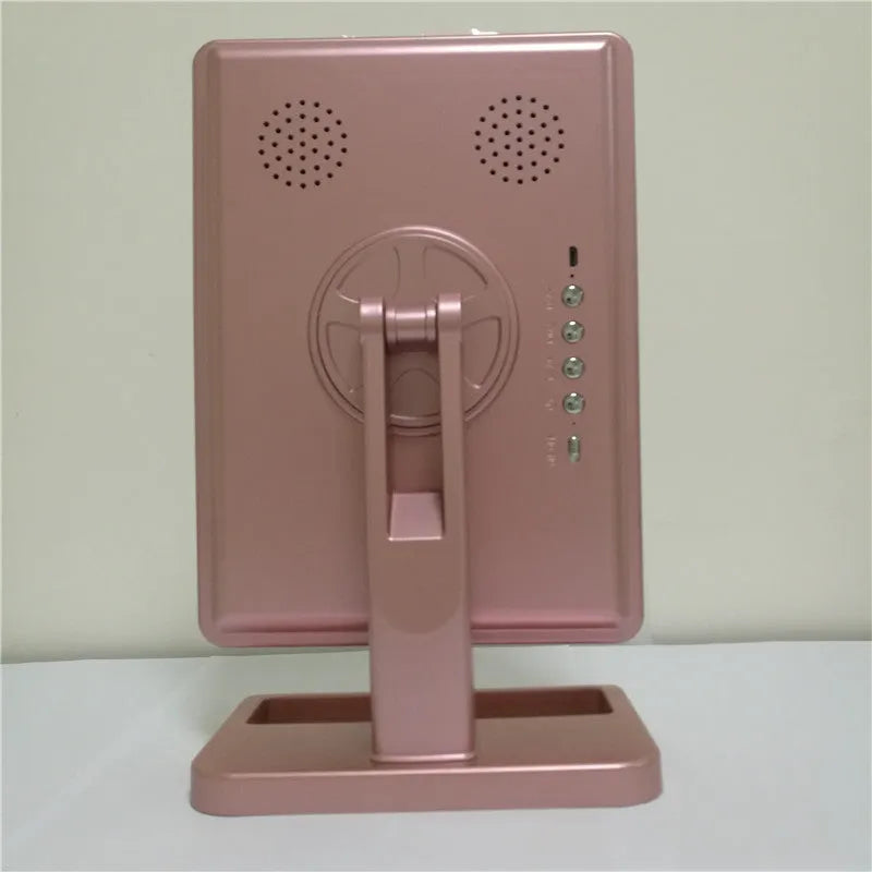 Pink and white LED makeup mirror with a ring of lights, a 10X magnifying panel, and a Bluetooth speaker on a dressing table.
