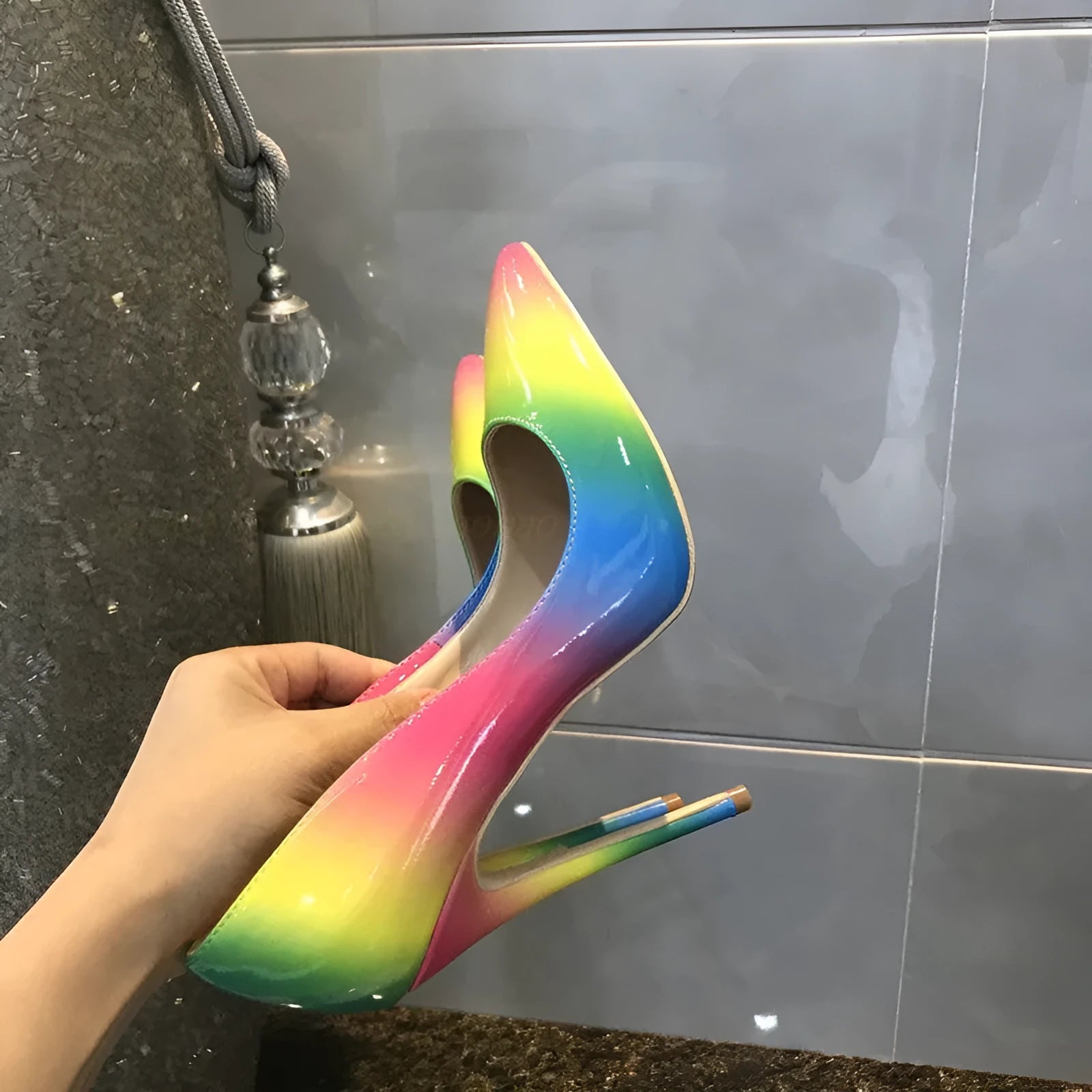 Rainbow coloured patent leather high heel shoes with a pointed toe and a thin stiletto heel.