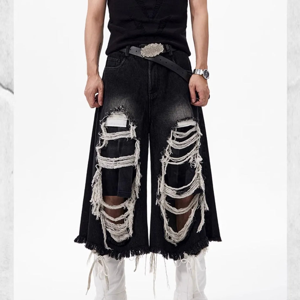 Black wide leg cropped jeans with distressed patch details and a mid-high waist.