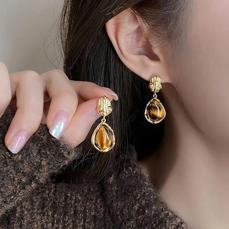 Three pairs of geometric earrings with tassel detailing in different styles: round, irregular, and water drop shapes.