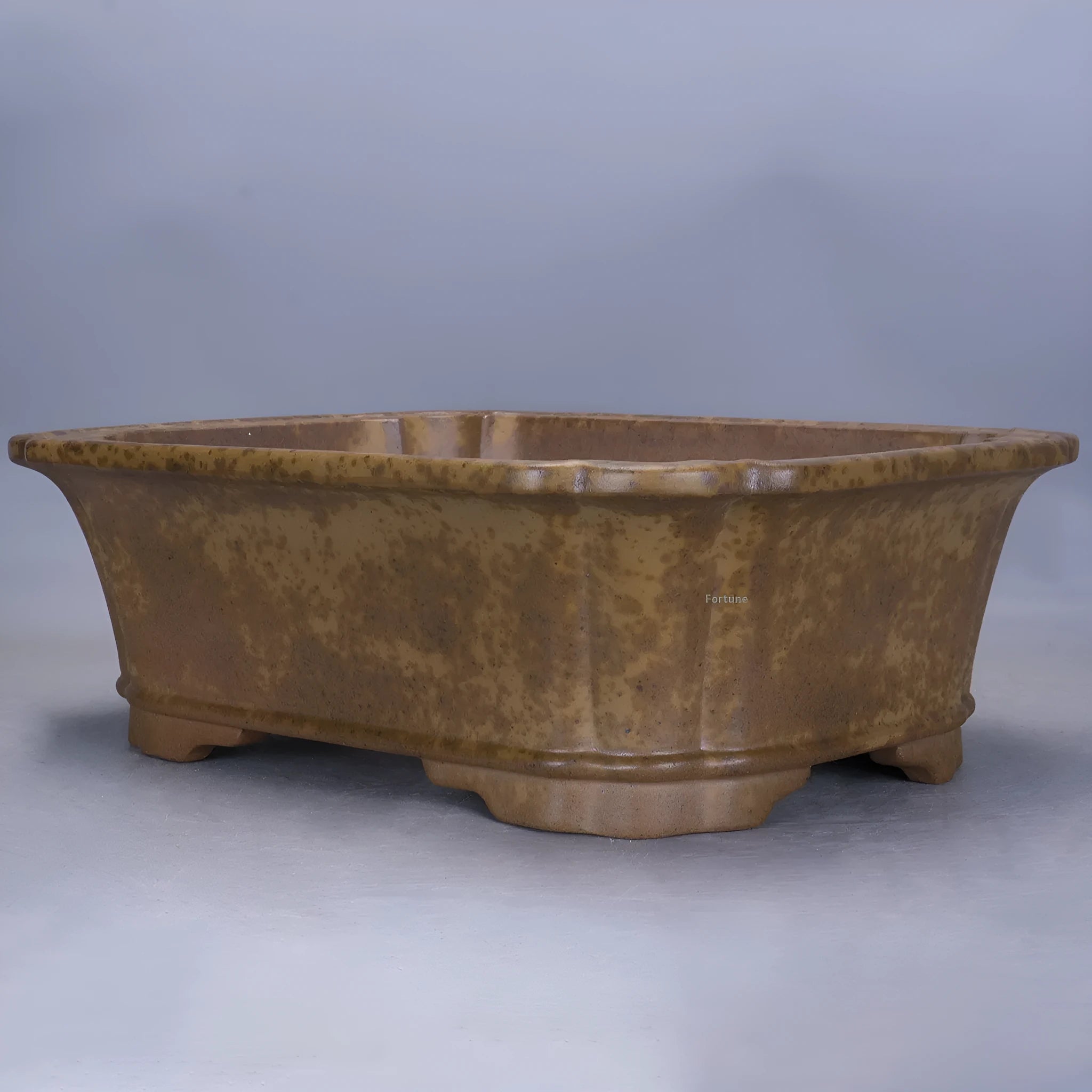 A large, modern rectangular purple sand ceramic flowerpot with sharp angles, shown on a patio.