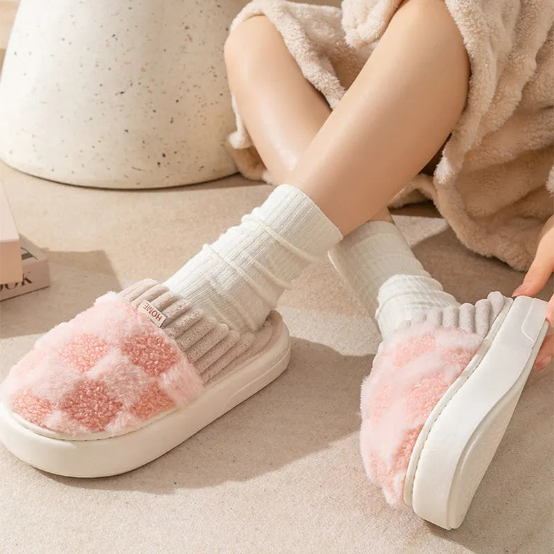 Plaid pattern women's plush indoor slippers in grey with a round toe and flat heel on a non-slip sole.