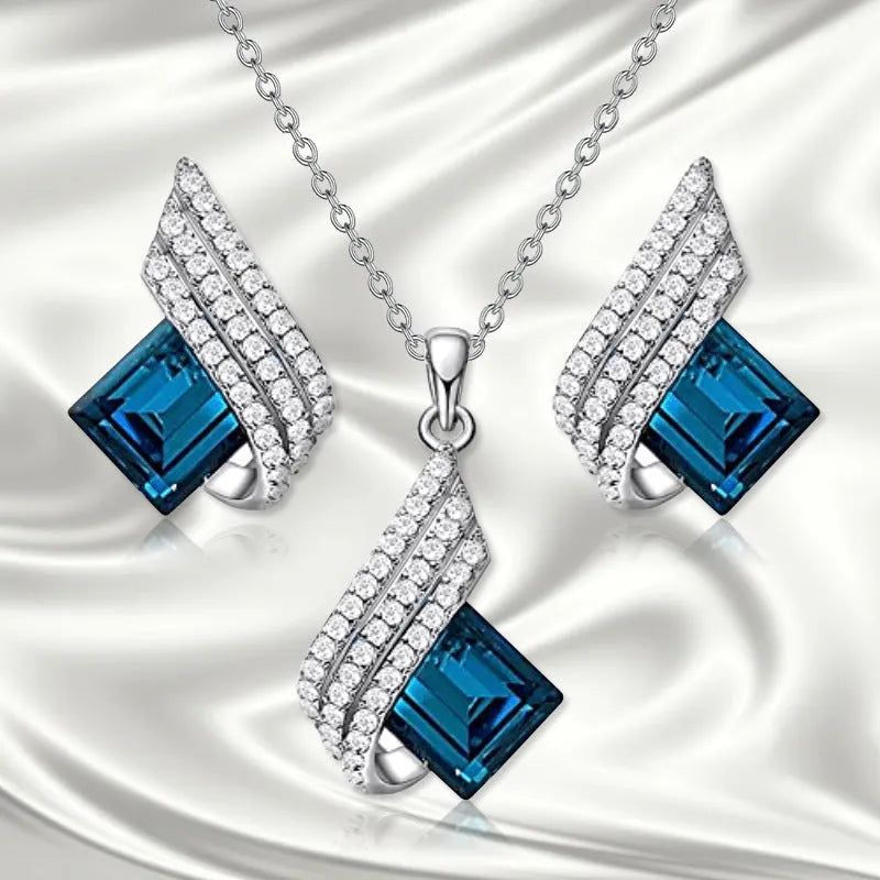 Silver-toned necklace and earrings set with glass pendant on cross chain
