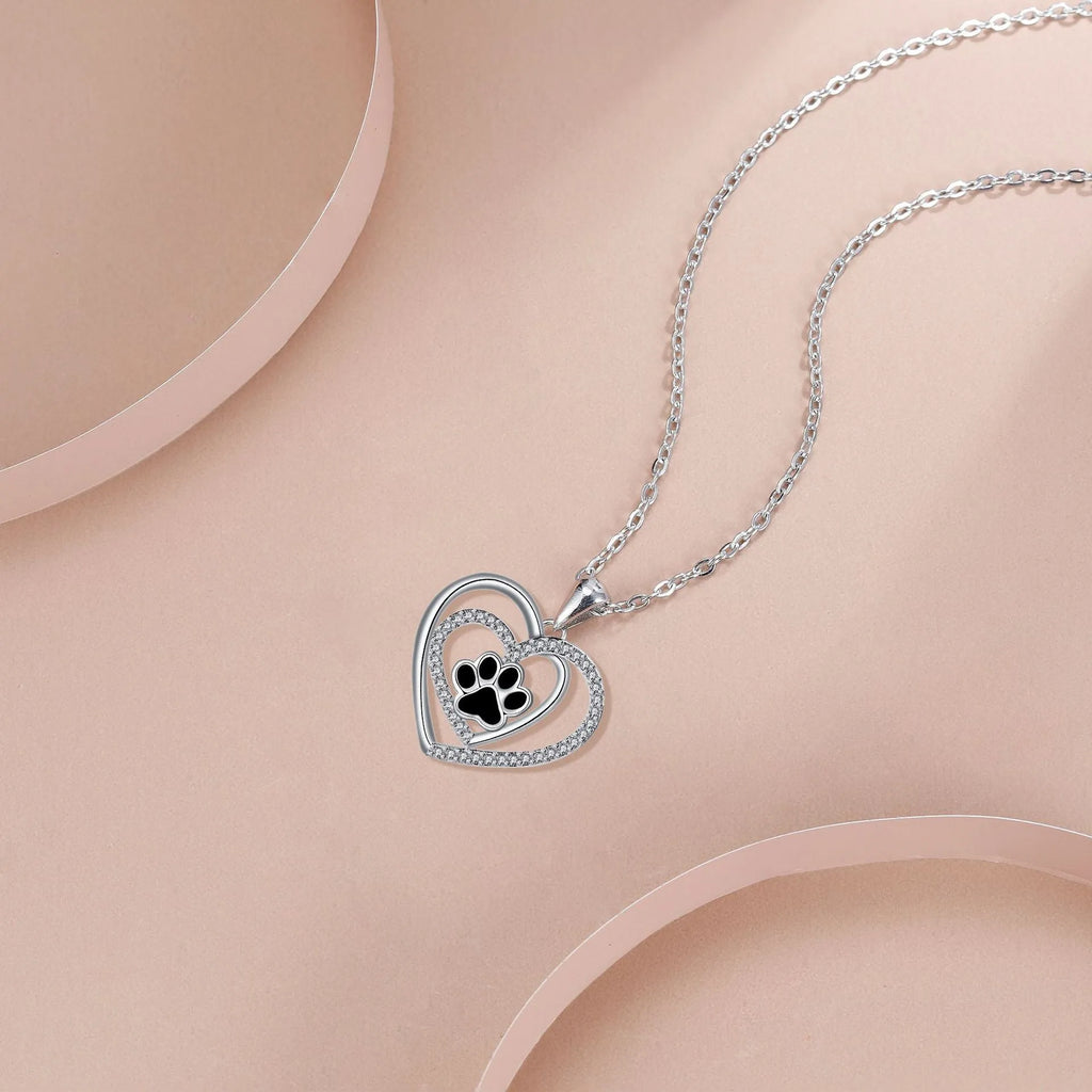 Women's copper dog paw print heart necklace on a cross chain.