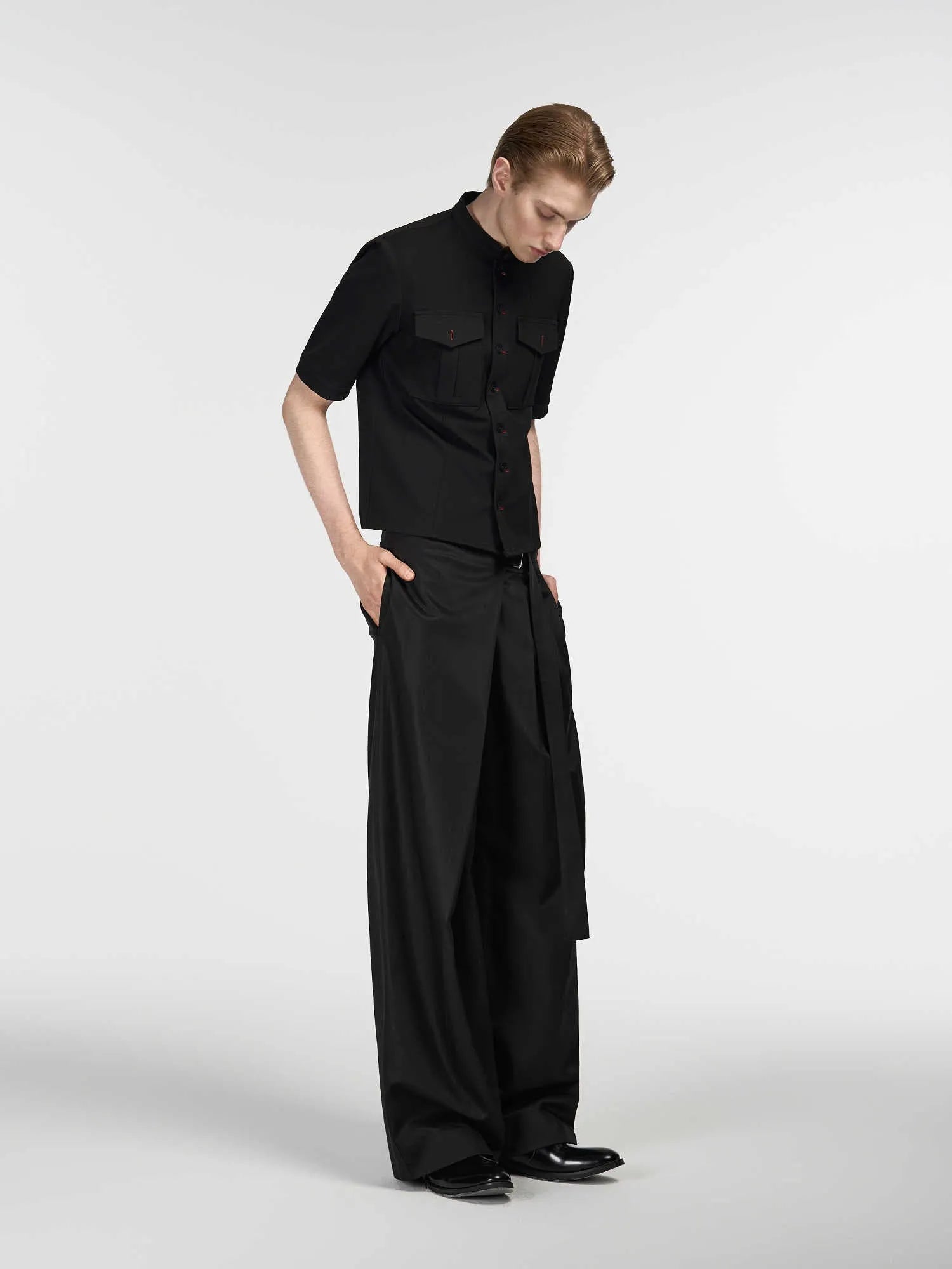 Black straight-leg trousers with a single pleat and adjustable waistband laid flat.