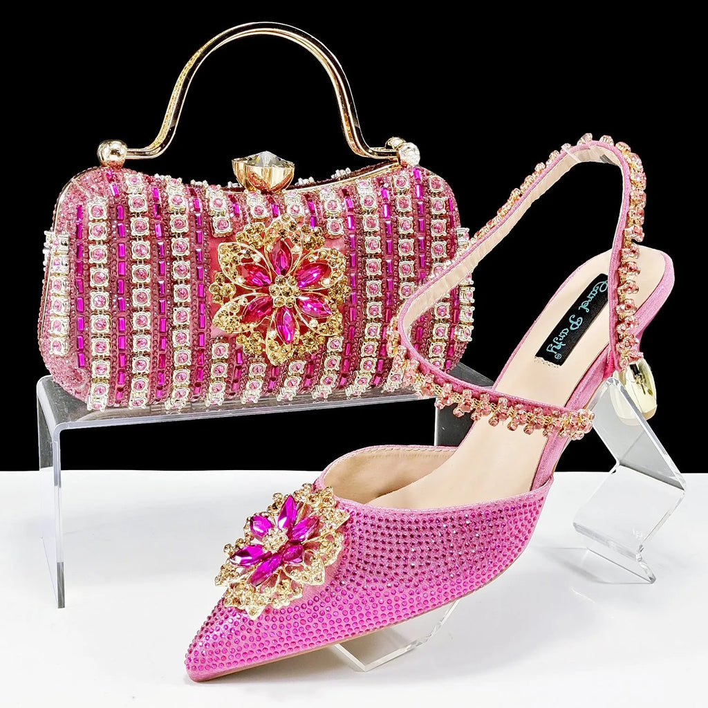 Black high heel ankle strap shoes with floral buckle and matching rhinestone clutch bag.