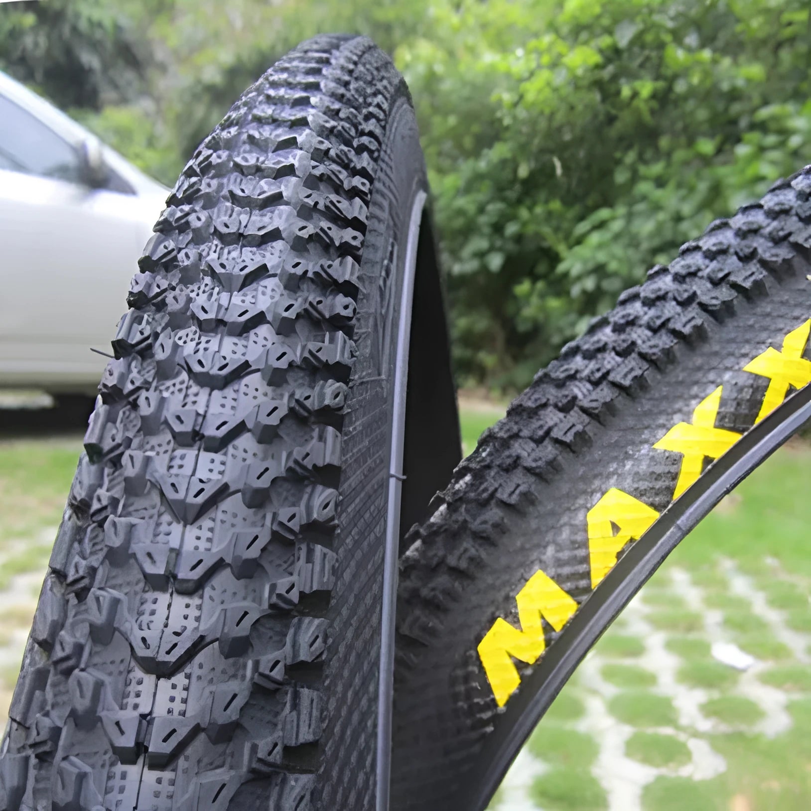 A mountain bike tyre showing tread pattern, with options for 26, 27.5, and 29-inch wheel sizes.