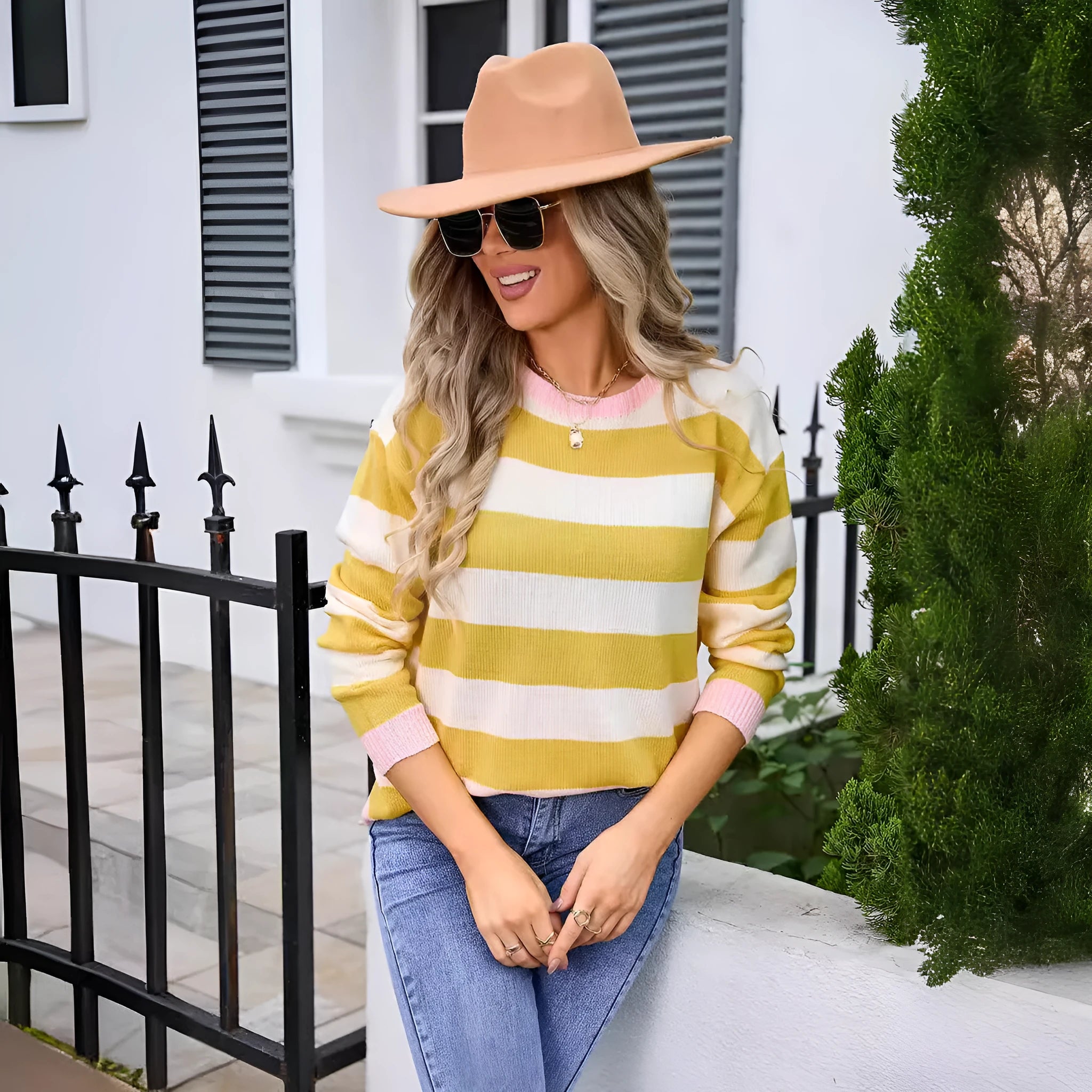 Women's loose blue acrylic sweater with stripes, round neck, and long sleeves on a hanger.