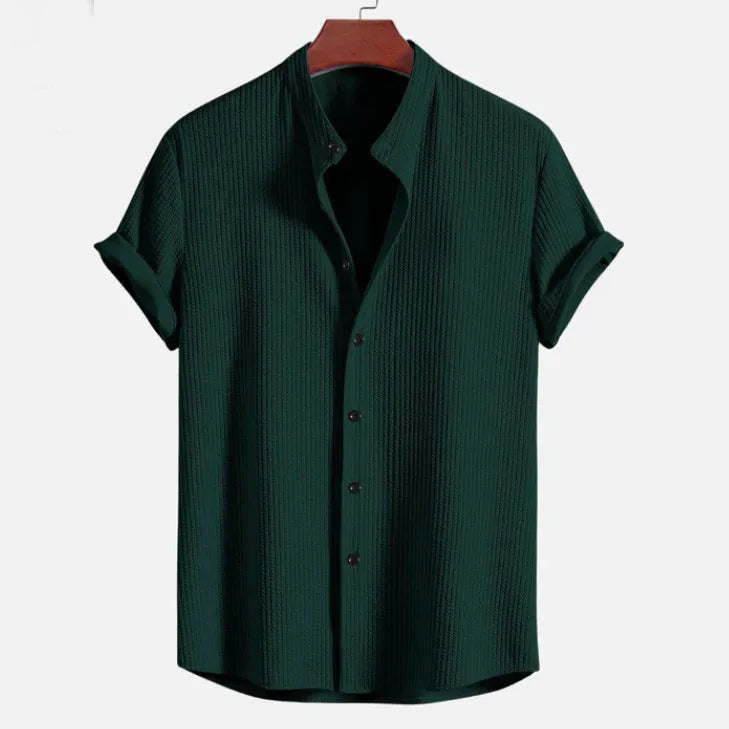 A man's loose-fitting short sleeve casual shirt in a solid colour, made from lightweight polyester fabric.