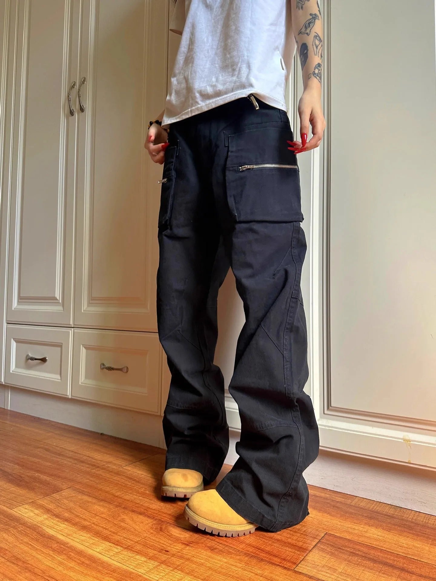 Green and black double zipper casual cotton pants with an elasticated waistband on a hanger.