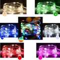 Copper wire string light with warm white LEDs wrapped around a wooden post
