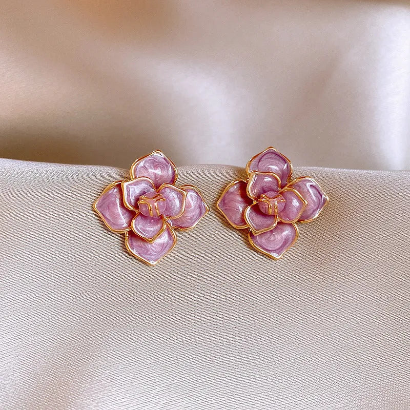 Gold plated purple oil-spot glaze flower stud earrings on a white background, showing detailed petal design and matte finish.