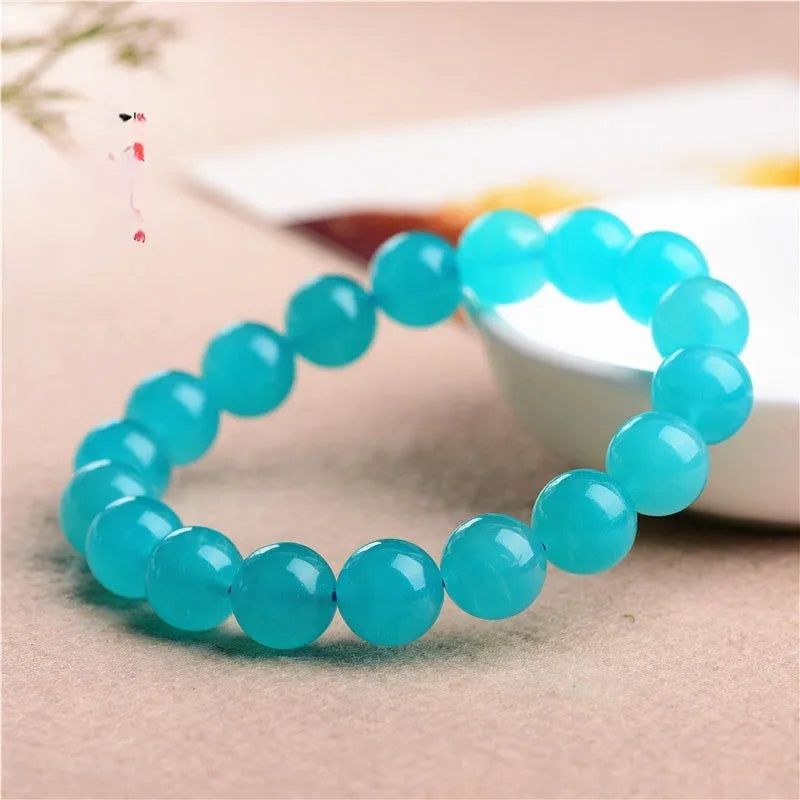 Loose natural green Amazonite beads in various sizes for jewellery making on a white surface.