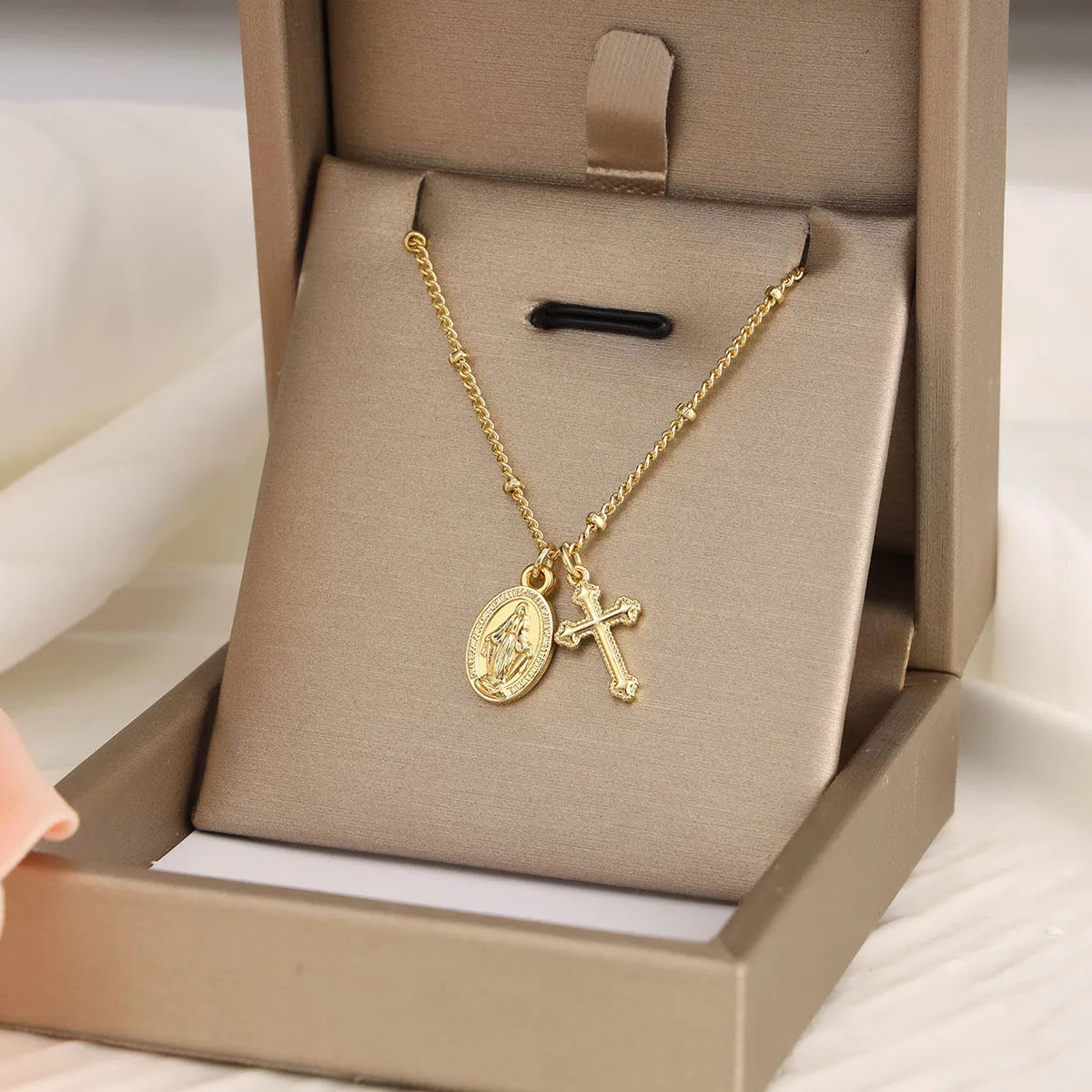 Gold geometric cross necklace with Virgin Mary detail on a 60cm chain, pendant is 3cm tall.