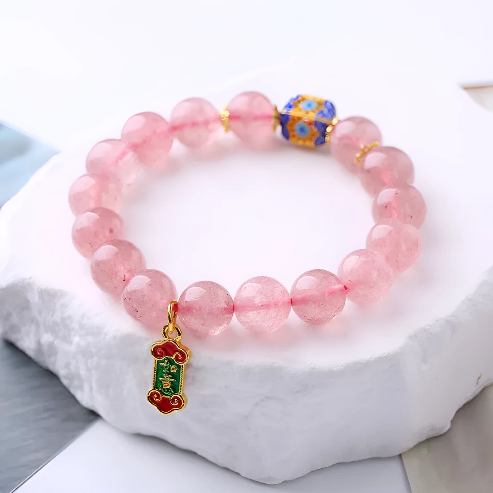 Pink strawberry quartz crystal bracelet with hand-woven construction and traditional Ruyi symbols