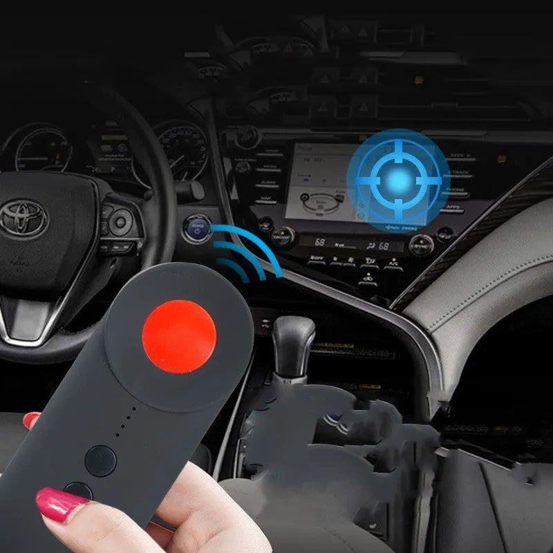 Black portable GPS and hidden camera detector with USB cable on a flat surface.