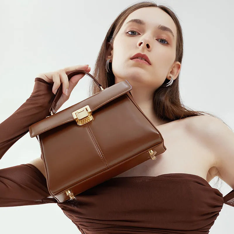Dark brown genuine leather women's shoulder bag with a clasp, showing its horizontal square shape and shoulder strap.