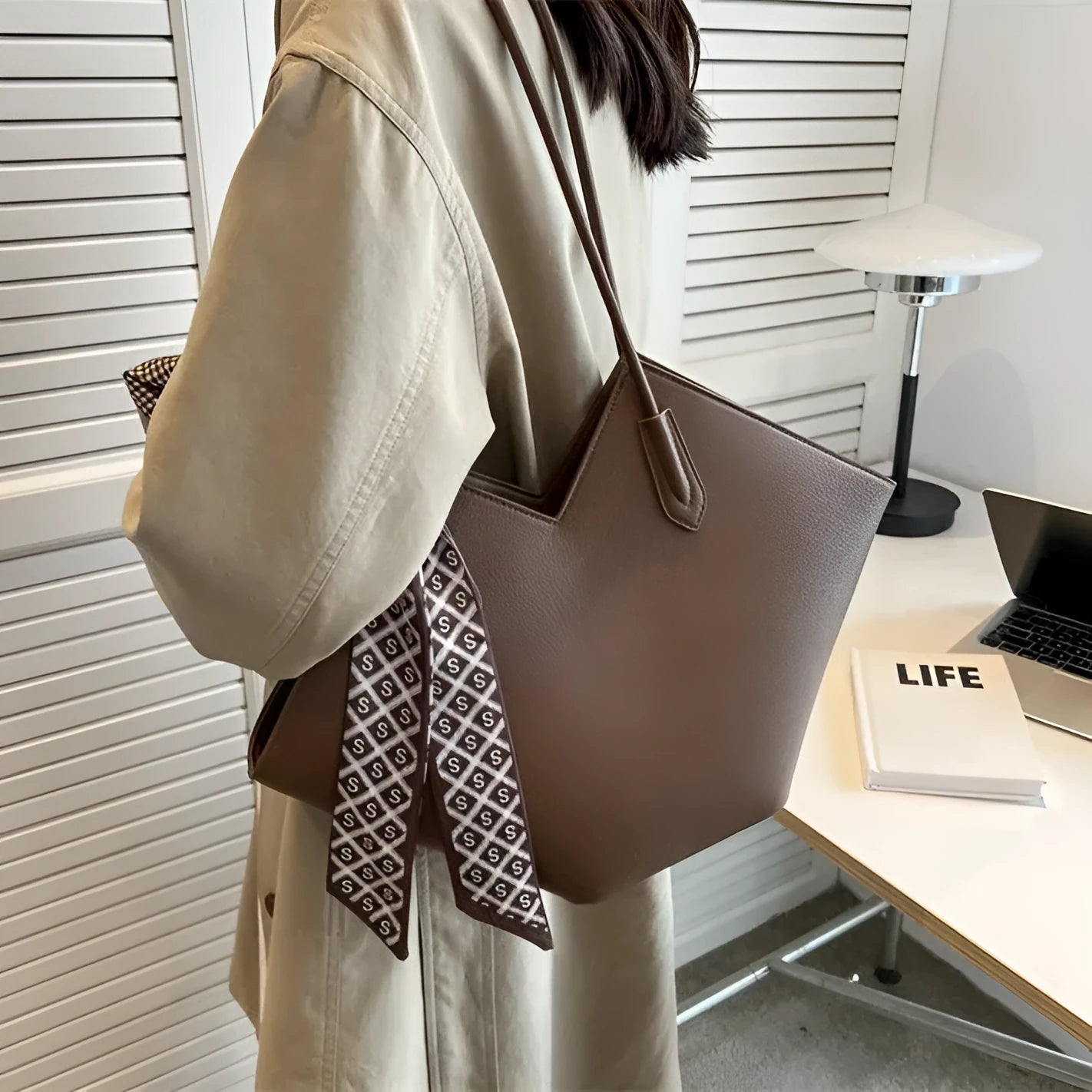 Beige women's large shoulder bag made of PU leather with multiple pockets and an adjustable strap.