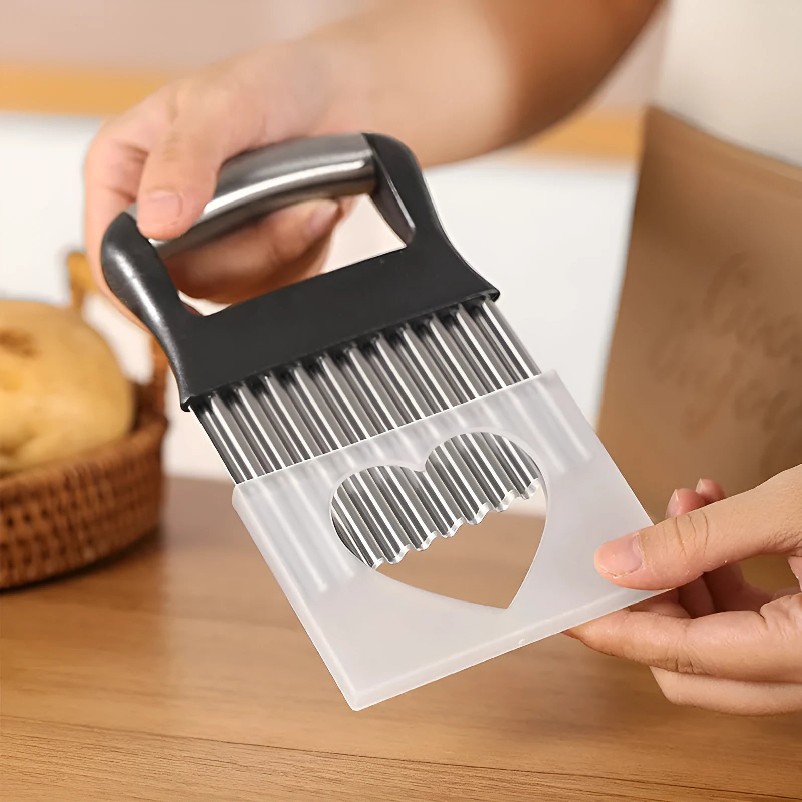 Stainless steel potato wave knife with a wavy blade on a wooden cutting board next to a potato.