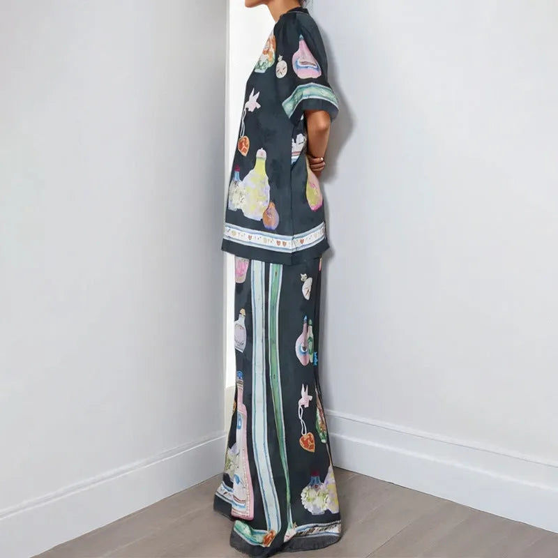 Black women's casual set with cartoon print, featuring a cardigan and matching trousers on a hanger.