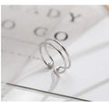 Silver plated geometric cross ring with adjustable opening on a plain background.