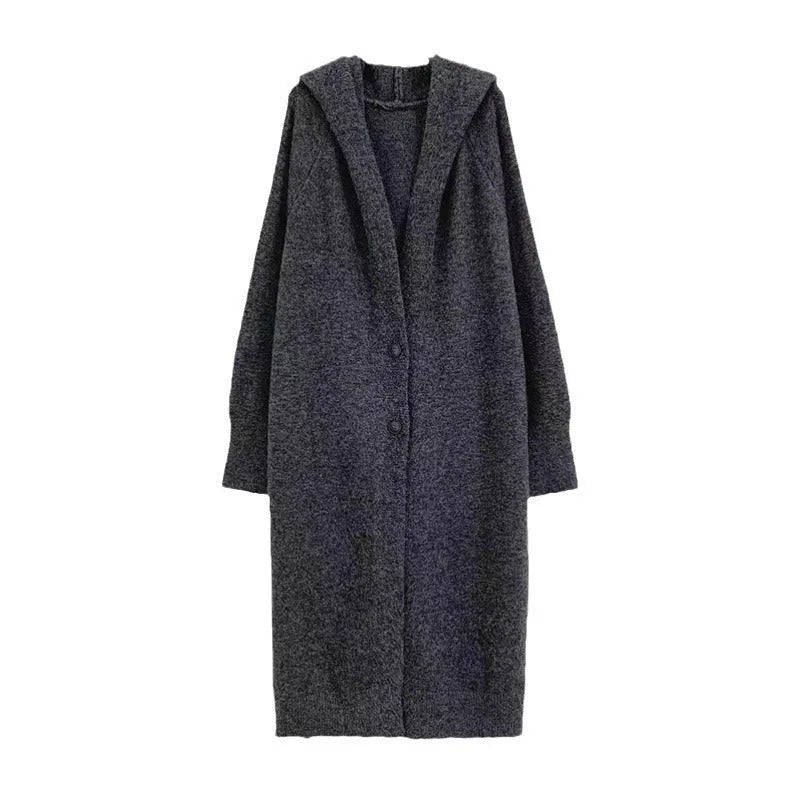 A woman wearing a long, loose, hooded knitted cardigan in a solid colour, demonstrating its below-the-knee length.