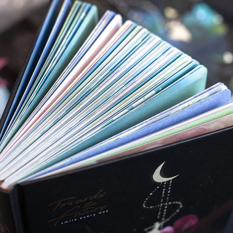 A5 notebook with luminous holographic cover open to show colour illustration on inside pages.