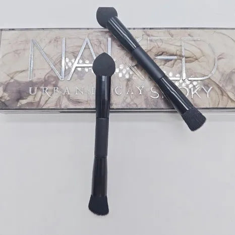 Black double-headed concealer brush with sponge end and tapered brush end on wooden handle