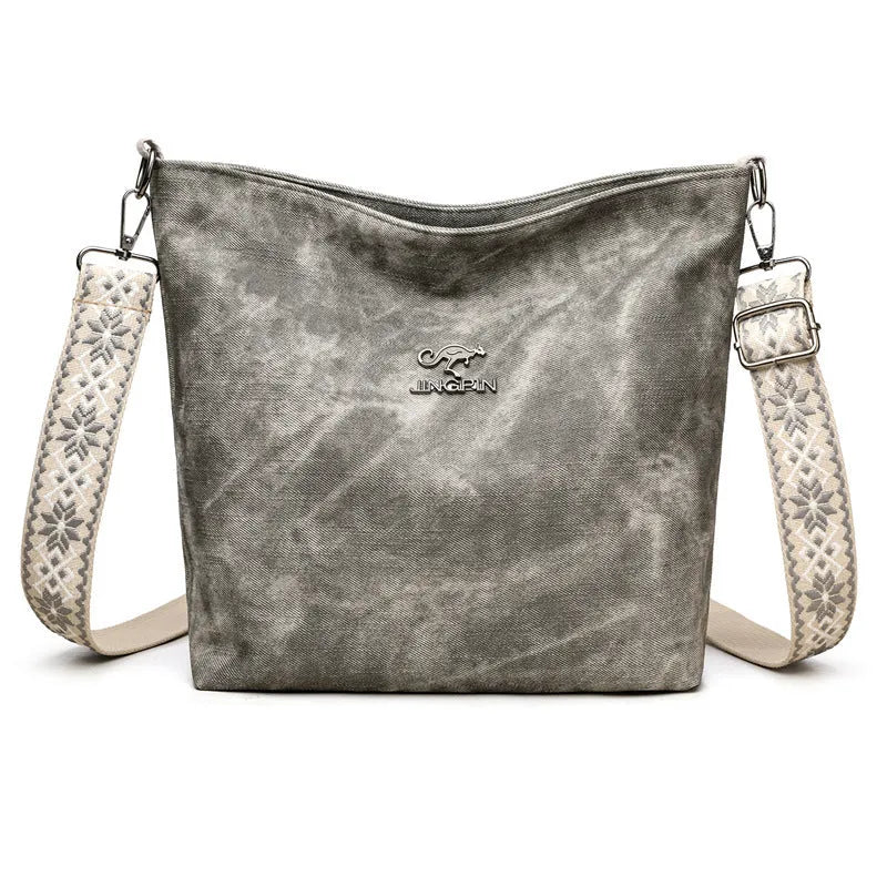 A soft pink large capacity women's crossbody bag made from PU leather with an adjustable strap.