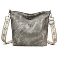 A soft pink large capacity women's crossbody bag made from PU leather with an adjustable strap.