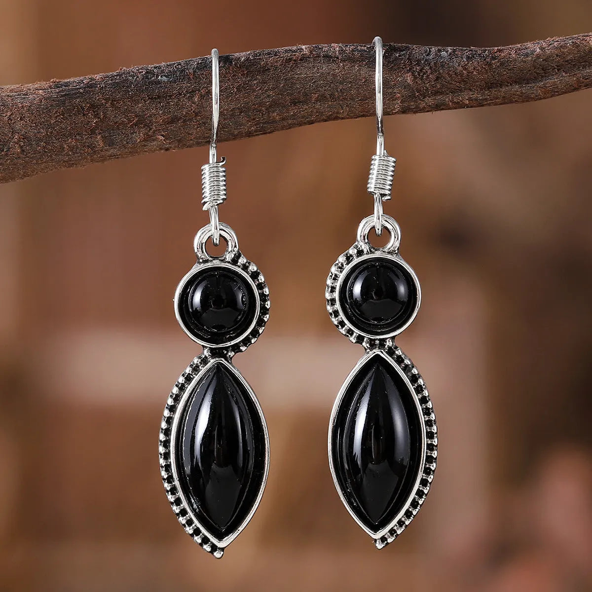 A pair of black and purple vintage geometric drop earrings with a round detail, shown against a plain background.