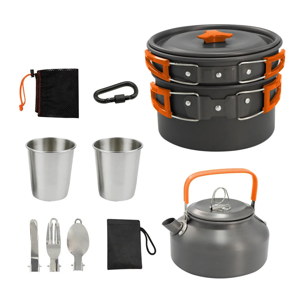 Green aluminium alloy camping teapot set with kettle, frying pan, and pot arranged on a picnic table