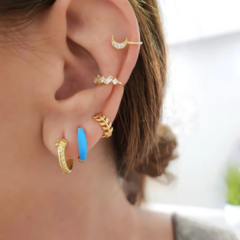 A pair of glossy, U-shaped epoxy oval earrings with a round ring detail on silver copper posts.