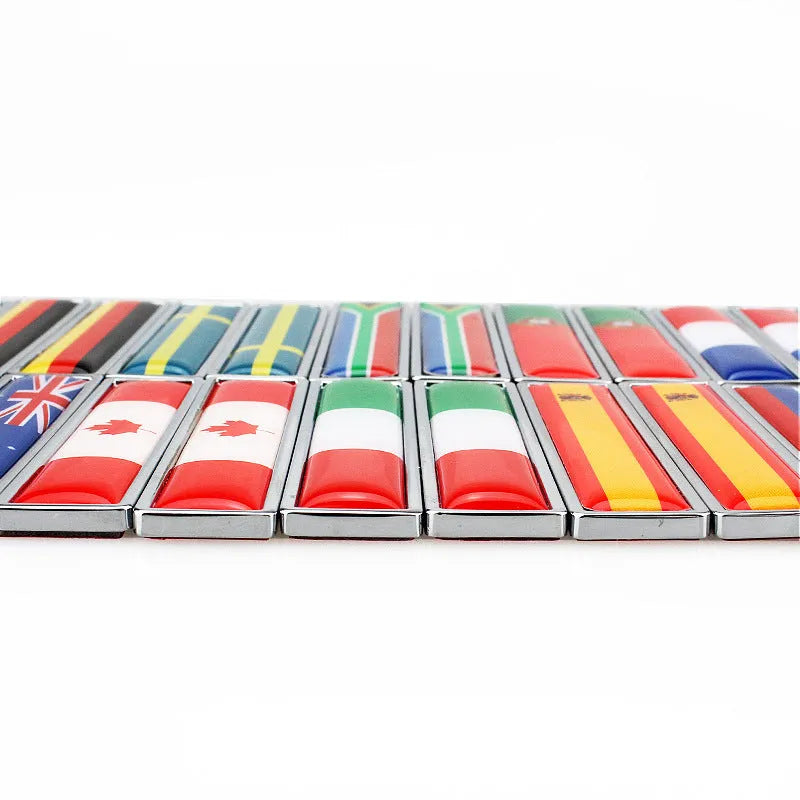Pair of rectangular zinc alloy metal car badge stickers showing national flag designs, dimensions 58mm by 14mm.