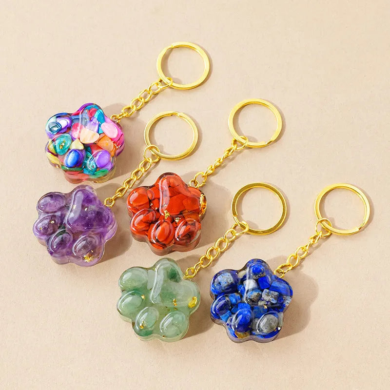 Small cat's paw shaped keychain pendant made from a natural pink crystal on a metal ring.