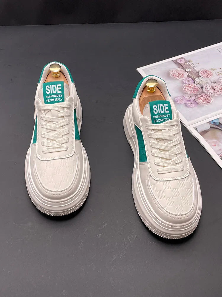 A pair of white and green sports-style casual shoes with a cloth upper on a plain background.