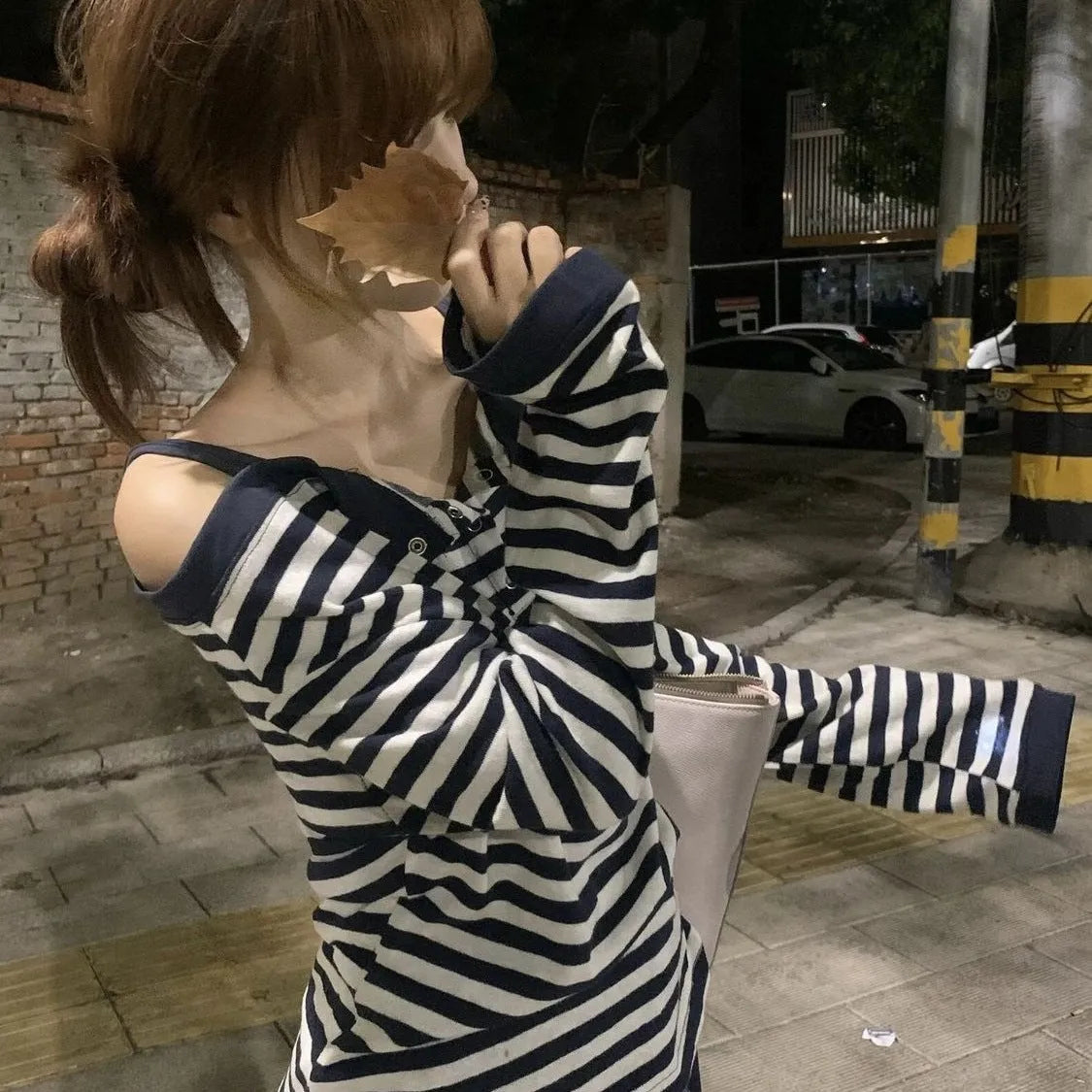 Dark blue women's oversized long-sleeved t-shirt with embroidery and stripe details on a hanger.