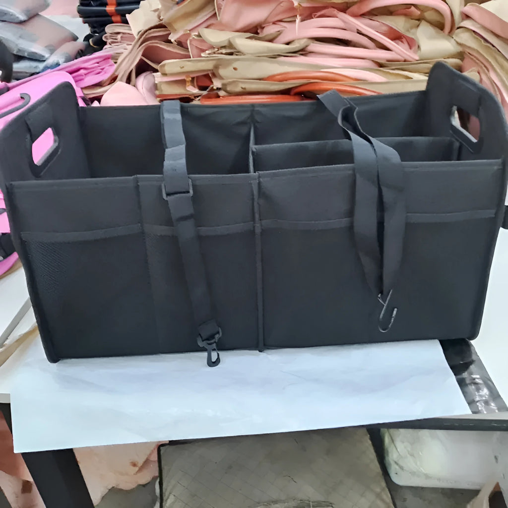 Foldable multi-compartment fabric car trunk storage box in black with a handle.