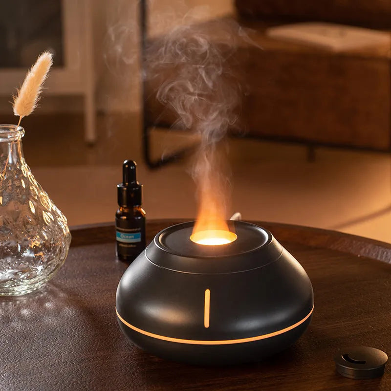 Round white aroma diffuser with colourful LED flame effect on desktop