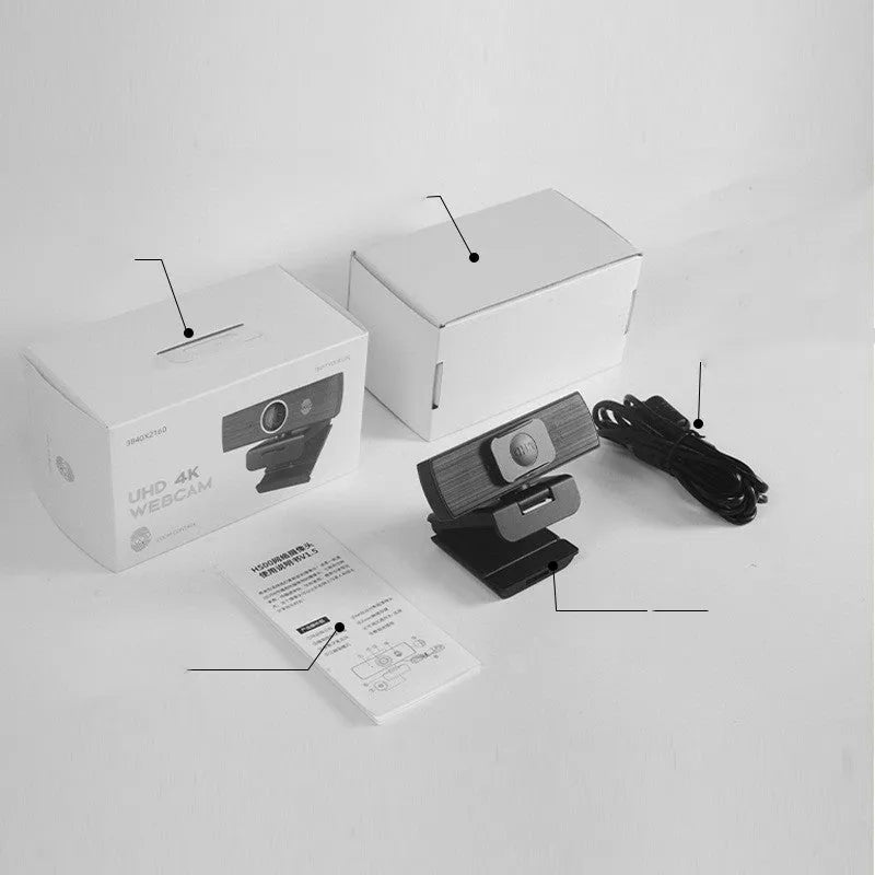 Black ABS plastic USB computer webcam with a detached magnetic privacy cover on a desk.