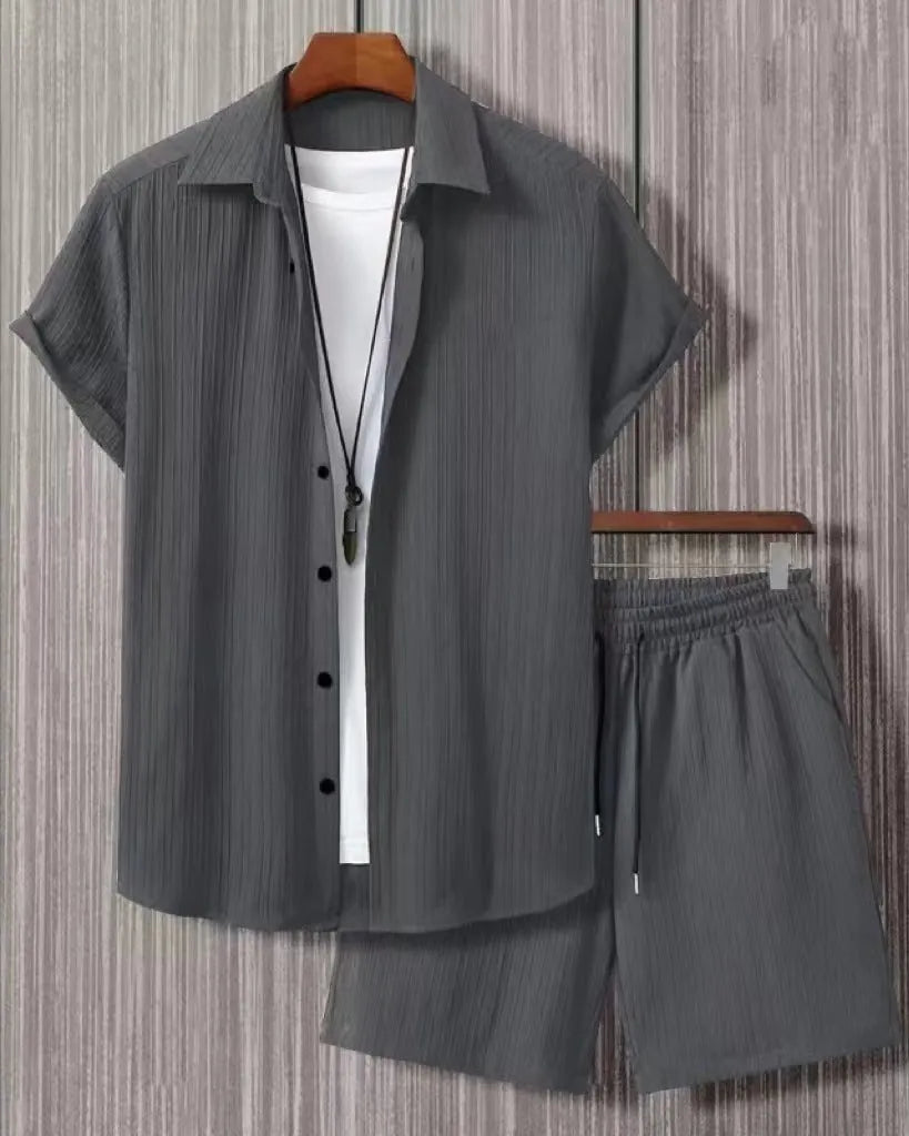 Man wearing a black and white jacquard patterned short sleeve suit shirt with matching formal shorts.