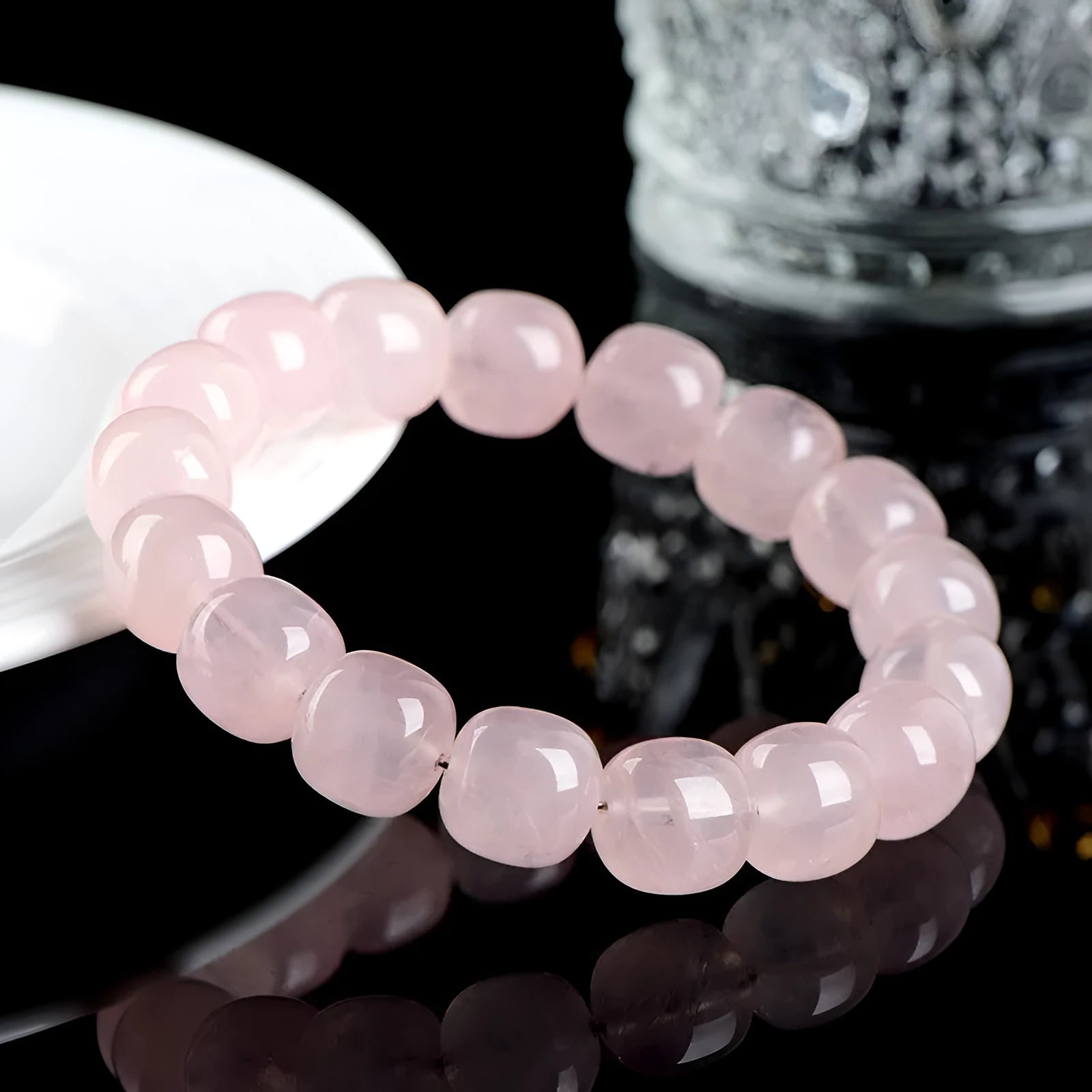 Pink crystal barrel bead bracelet with geometric design on a bamboo string.