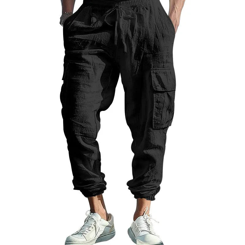 Men's loose-fit linen trousers with ankle ties and a drawstring waist in a solid colour.