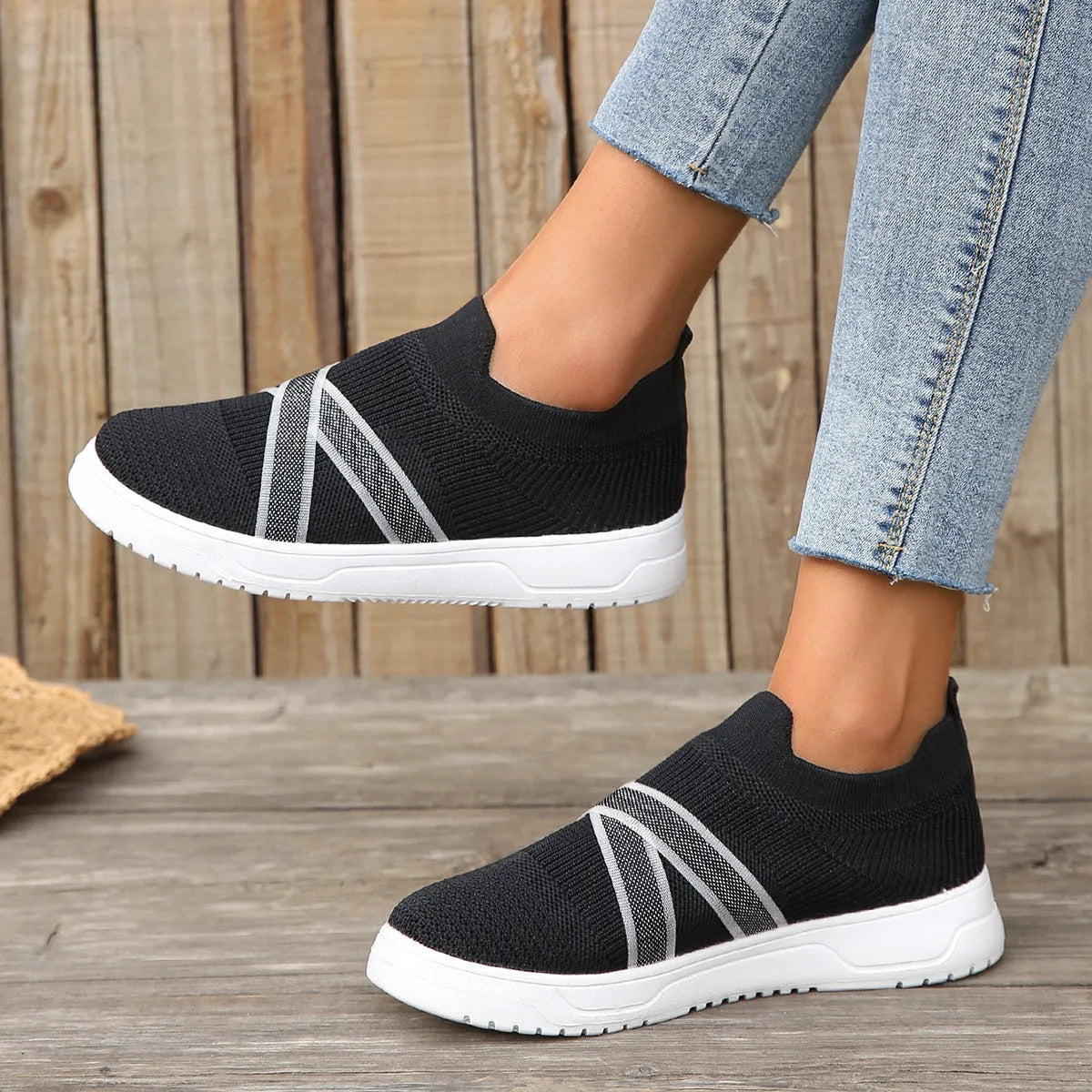 Women's black flyknit mesh outdoor shoes with flat rubber sole and tassel detail.